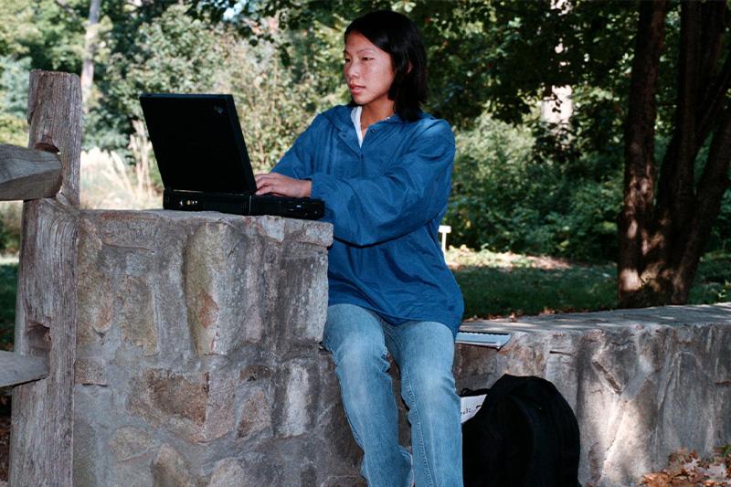 A student using her 1990s-era laptop on the campus of UNC-Chapel Hill.